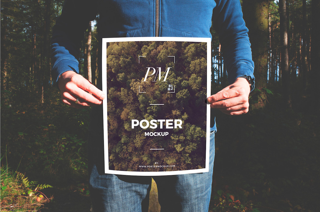 man in forest holding poster mockup