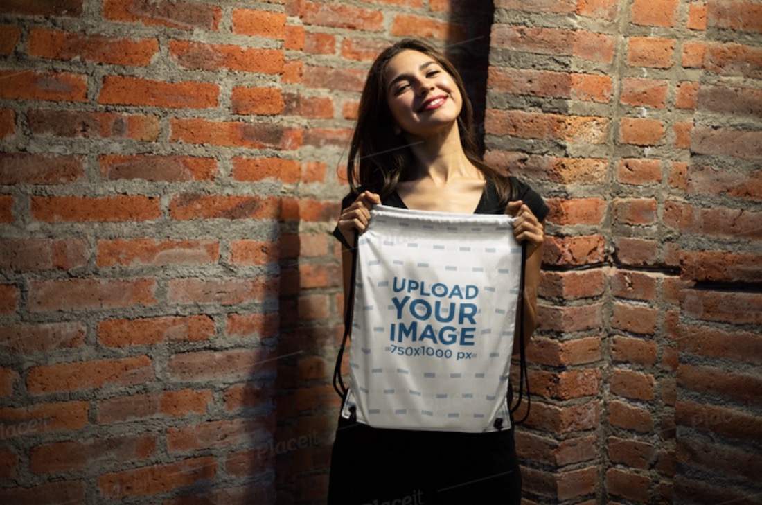 mockup of a happy young woman showing off her drawstring bag