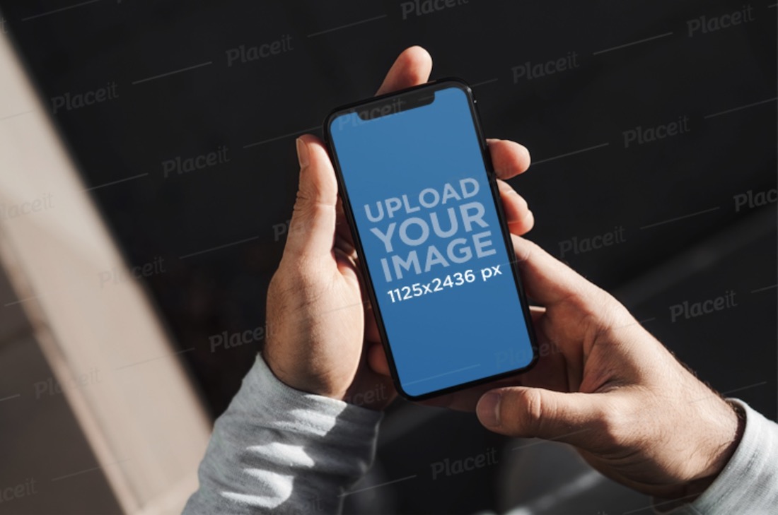 mockup of a man holding an iphone 11 pro with both hands