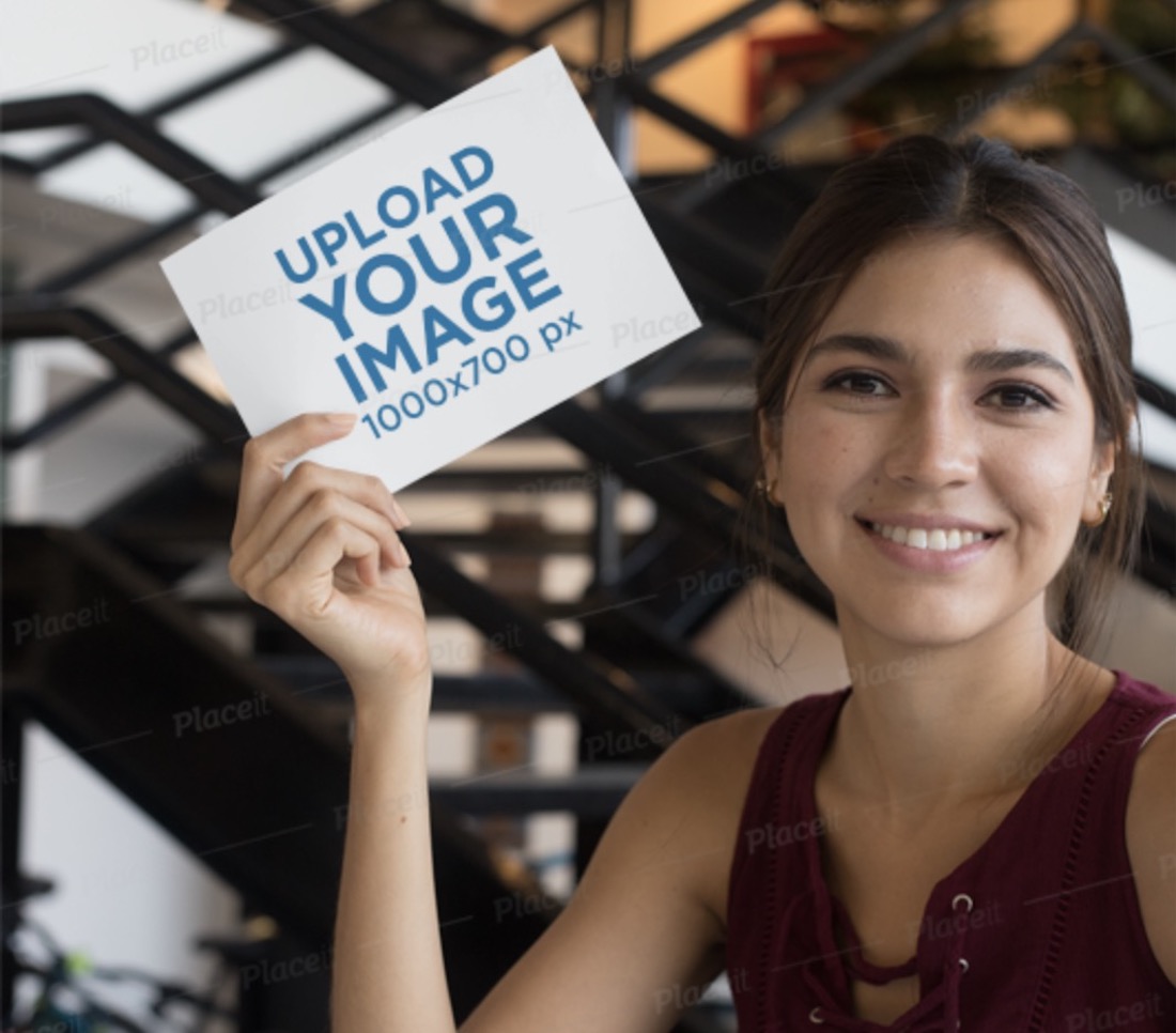 mockup of a smiling woman at a table holding an a5 flyer