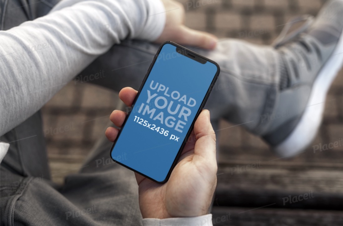 mockup of a young man holding an iphone 11 pro